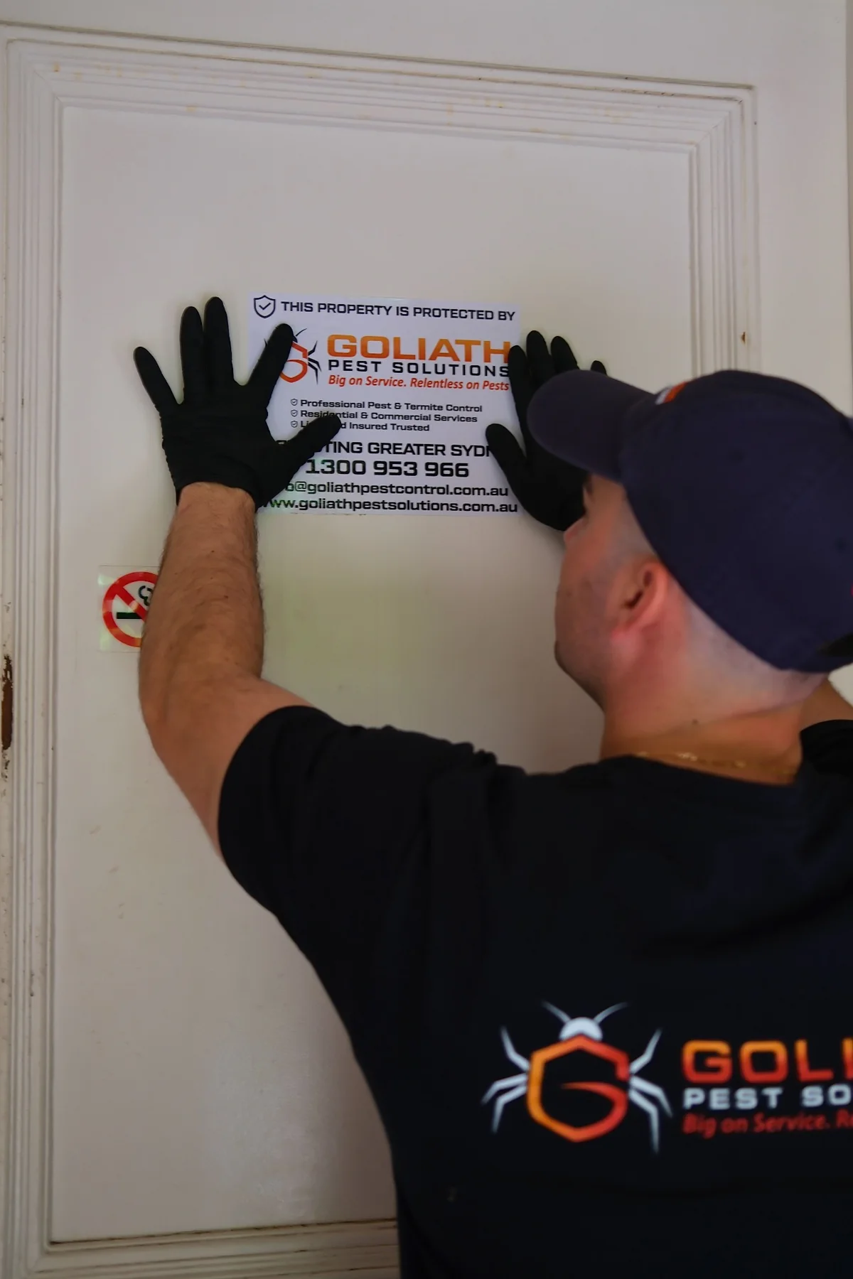 Goliath Pest Solutions technician installing property protection notice