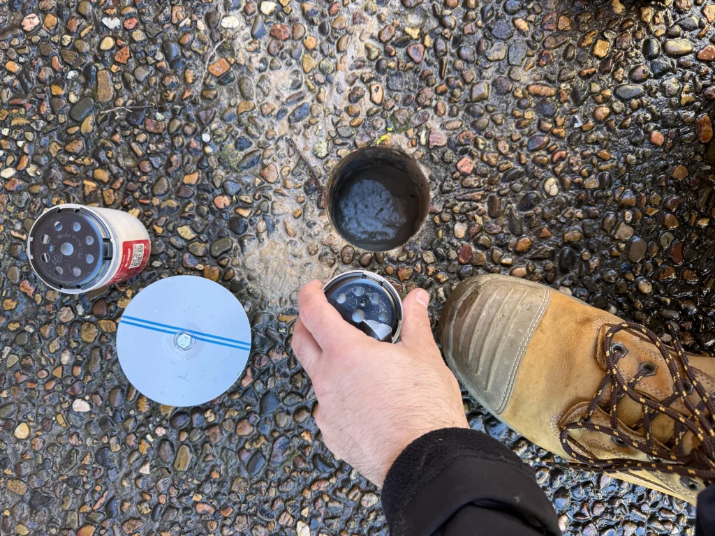 Close-up of a circular drilled opening in an outdoor hard surface