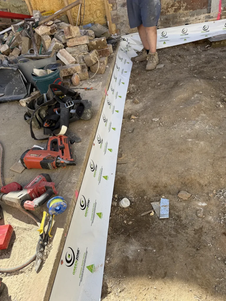 Protection strip and tools positioned along an exposed construction edge