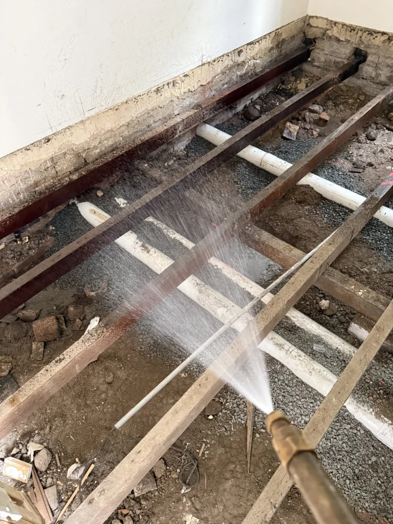 Spray directed toward timber floor framing in an exposed room