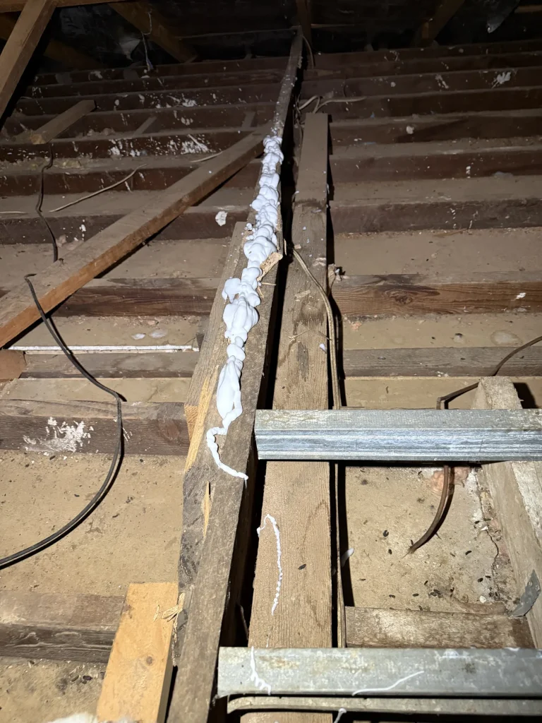Further view of damage along a timber beam inside roof framing