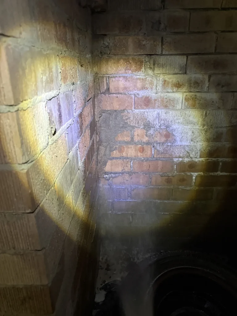 Brick junction and potential entry route examined with torch