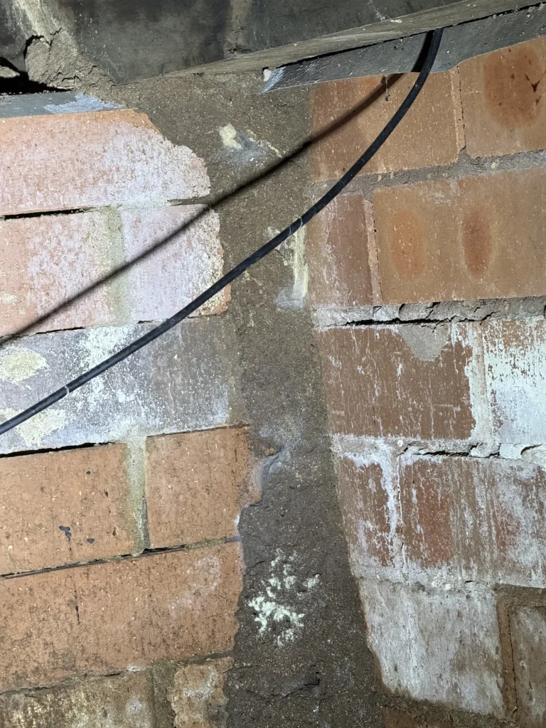 Close-up of vertical earthen trail on an internal subfloor brick pier