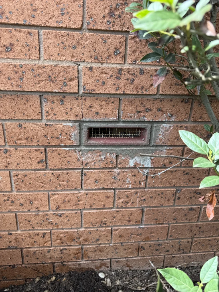 External brick wall and ventilation opening at a residential property