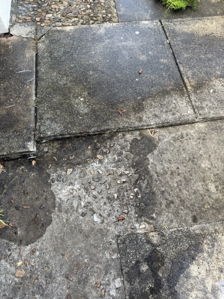 Dark mark or surface staining across an outdoor paved area
