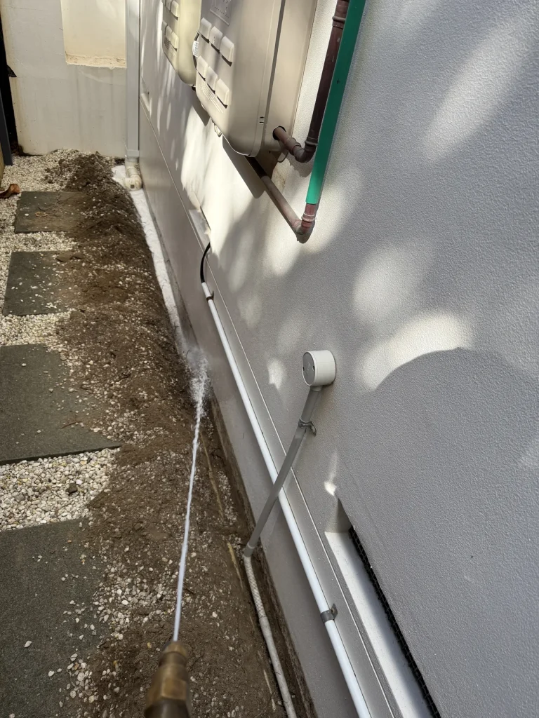 Exterior wall base and concrete path prepared for perimeter work