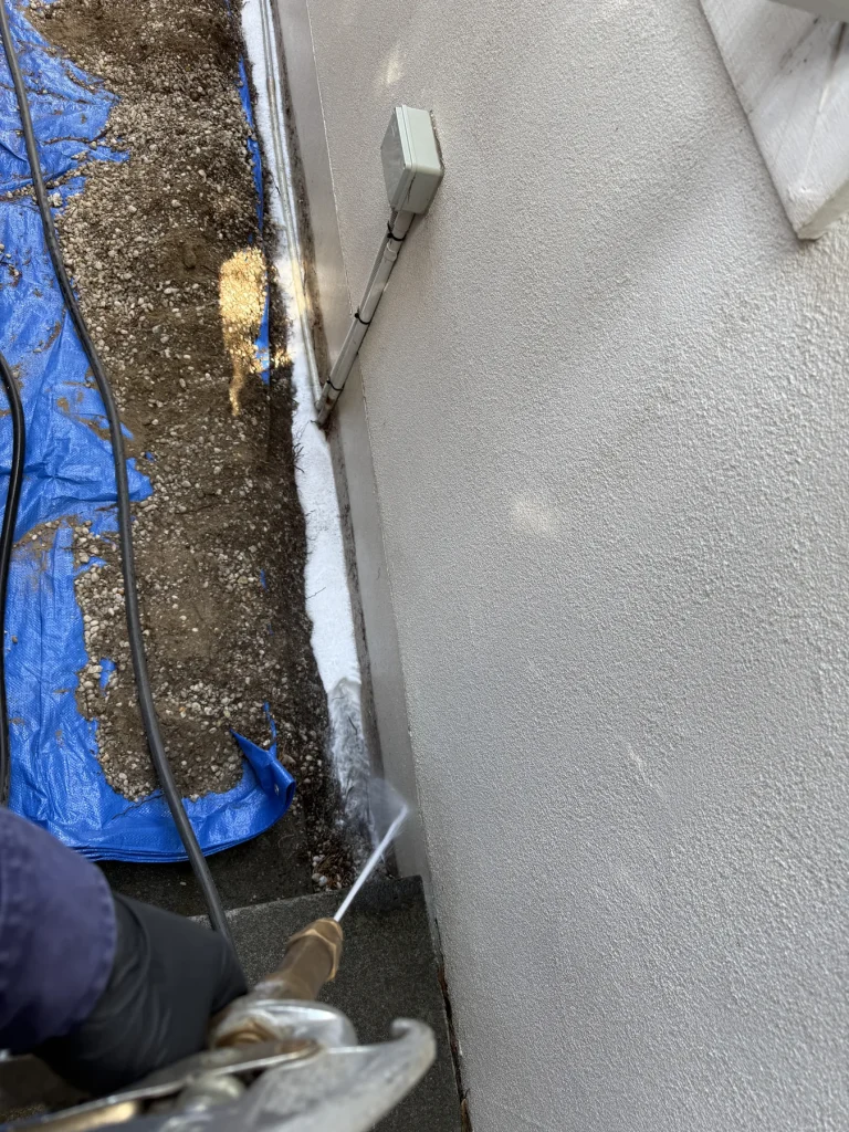 Protective blue sheet placed beside a dug exterior wall trench
