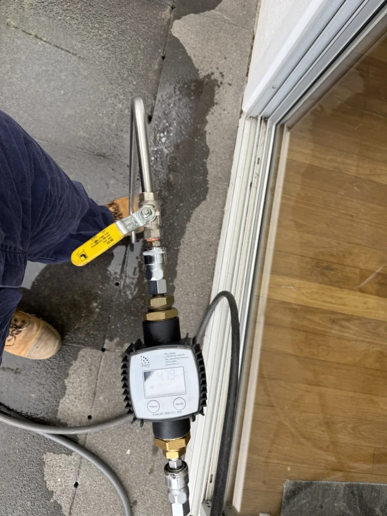Technician holding a measuring device beside a treated exterior wall