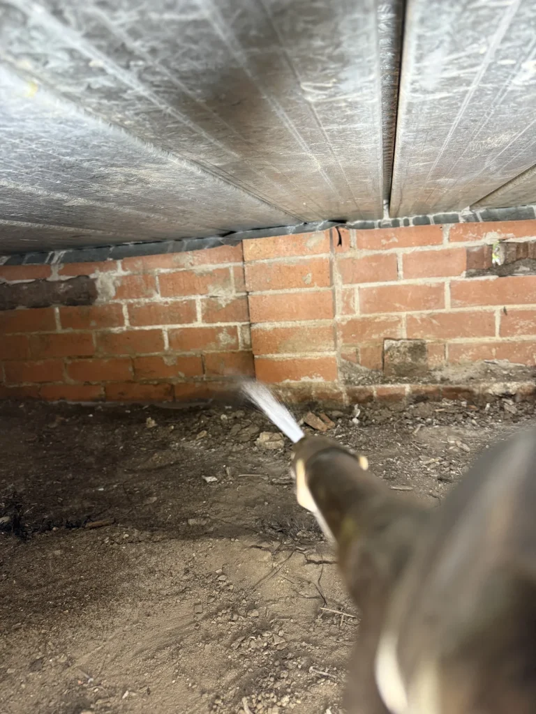 Subfloor pest-control treatment along brick foundations