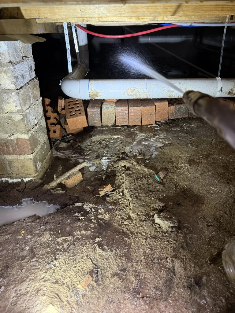 Residential crawlspace during subfloor pest-control treatment