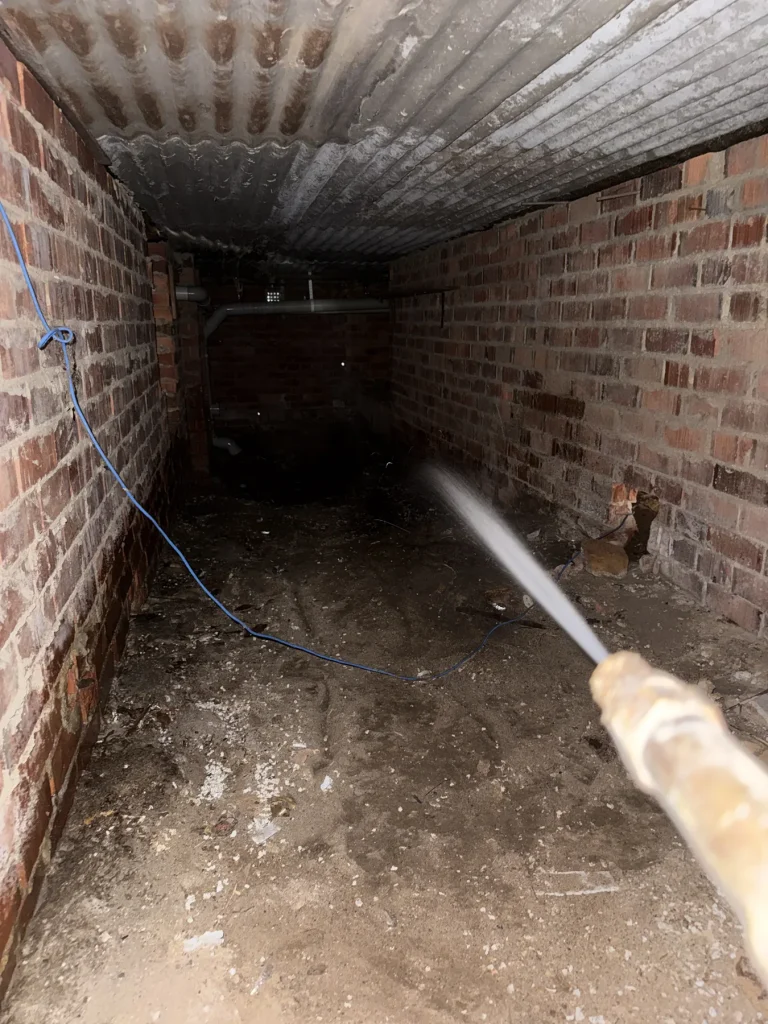 Treatment being applied through a narrow residential crawlspace